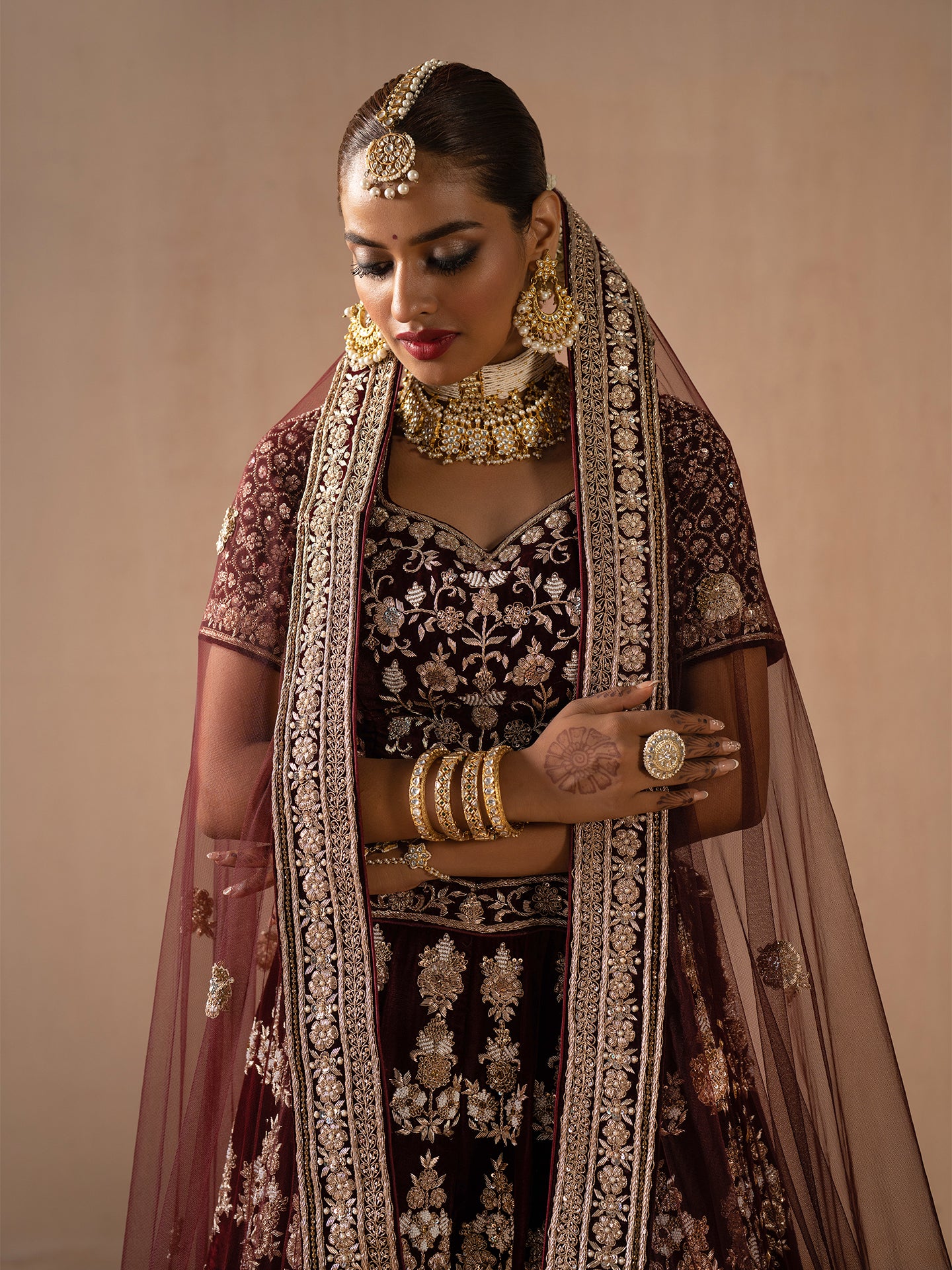 Luxurious maroon lehenga in silk with dabka work.