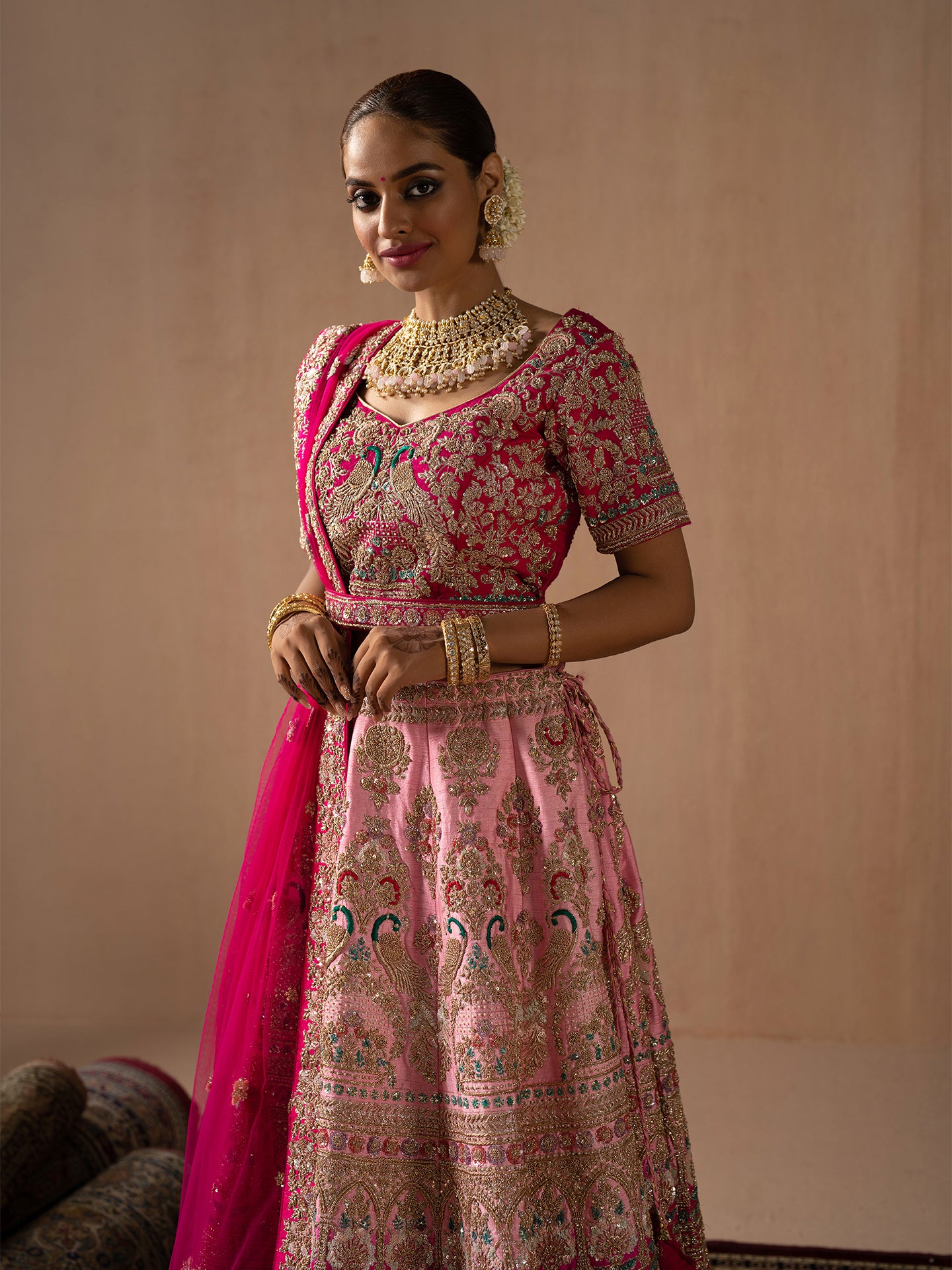 Luxurious pink lehenga in silk with golden dabka work.