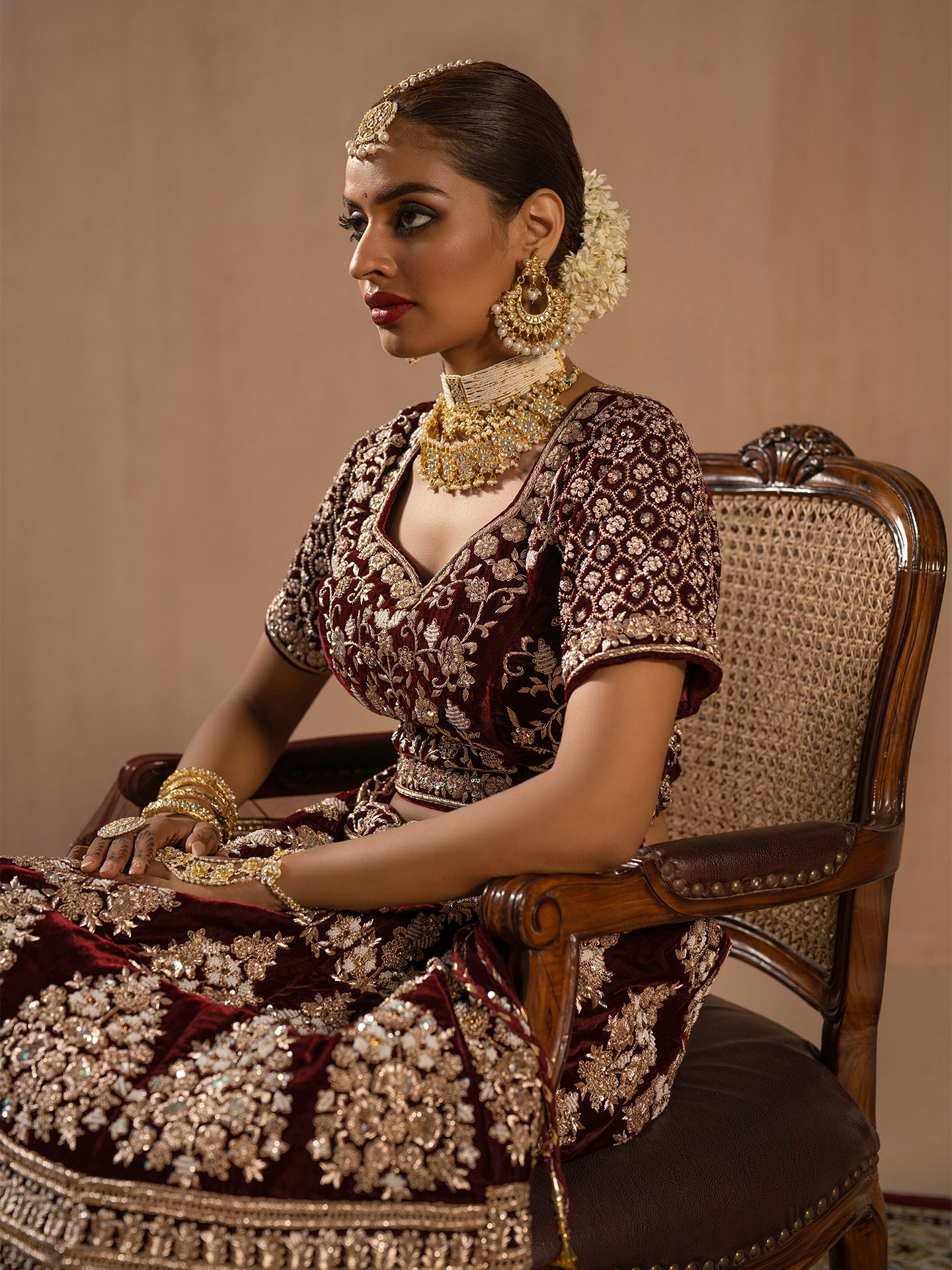 Luxurious maroon lehenga in silk with dabka work.