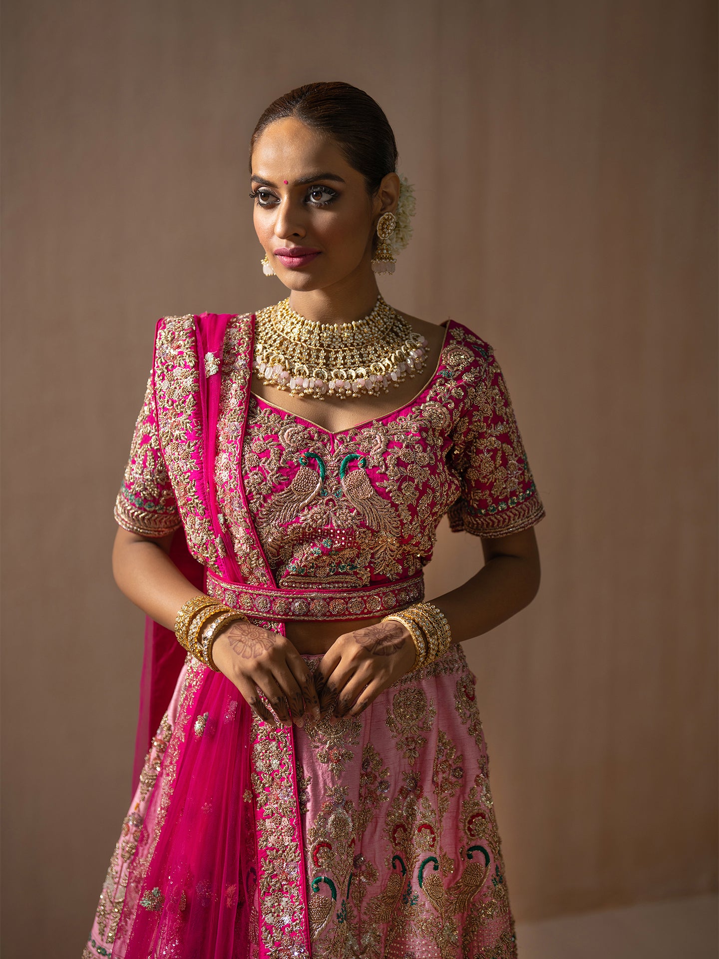 Luxurious pink lehenga in silk with golden dabka work.