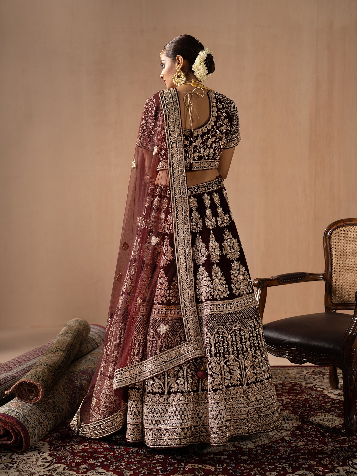 Luxurious maroon lehenga in silk with dabka work.